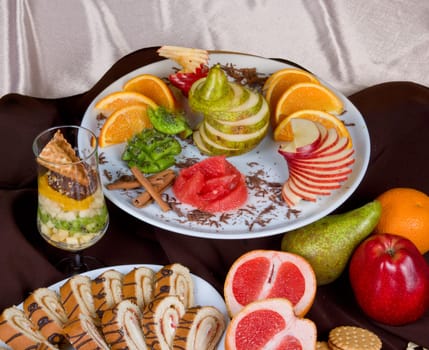 Set of sweet fruit and cake on a restaurant table background