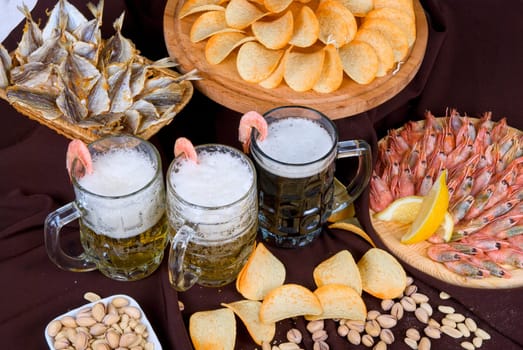 Beer and snacks set: chips, pistachio, shrimp and fish