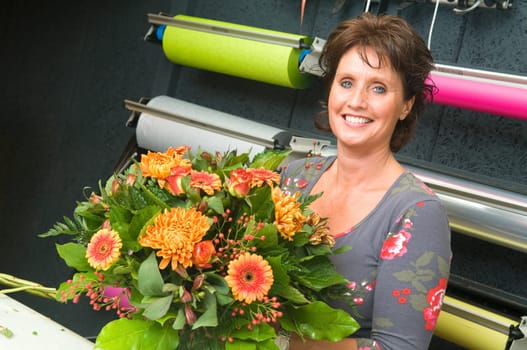 Female florist working in a flower store, making the bouquet ready for the customer