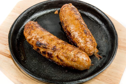 Two fried sausages at the pan close up