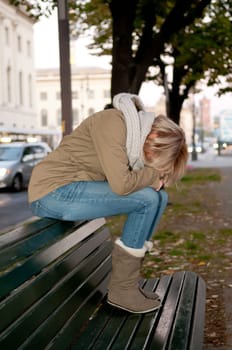 Sad young woman on a bench