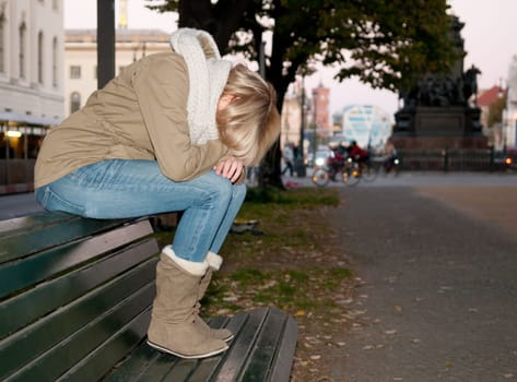 Sad young woman on a bench