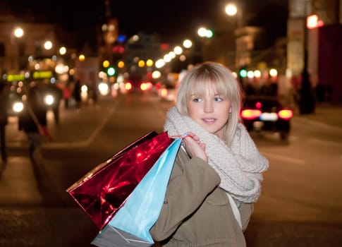 Young woman shopping in the evening big city