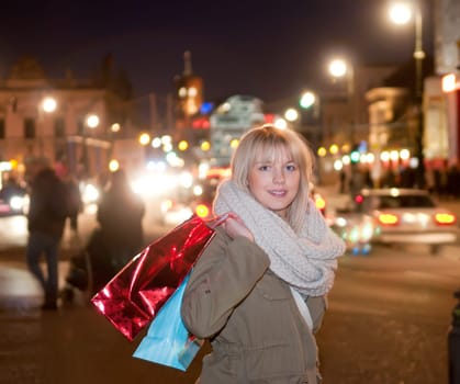 Young woman shopping in the evening big city
