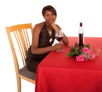 An African American woman is being courted by someone with flowers and red wine.