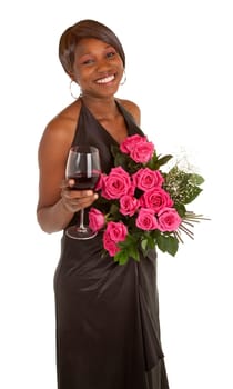 An happy african american woman is posing with her roses and a glass of red wine.