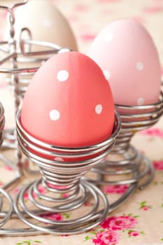Close-up of pastel colored Easter eggs in metal holders