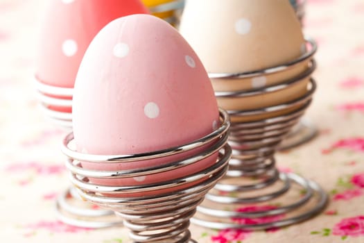 Close-up of pastel colored Easter eggs in metal holders