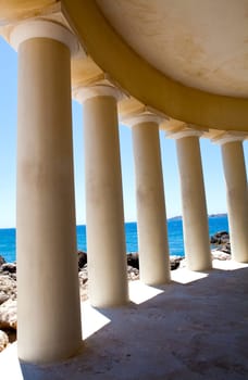 Lighthouse pillars with blue sea in the background in Argostoli, Kefalonia, Greece