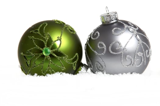 Two Christmas baubles in snow
