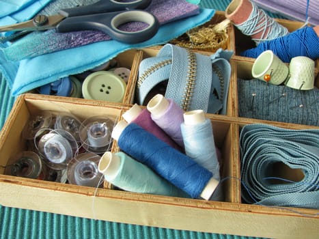 Blue sewing utensils in a wooden box