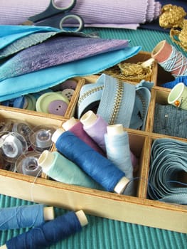 Blue sewing utensils in a wooden box