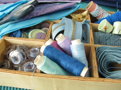 Blue sewing utensils in a wooden box