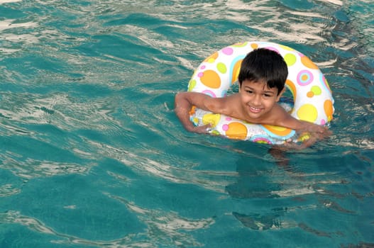 A handsome Indian kid playing in the pool