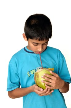 An handsome Indian kid drinking coconut water to cool off