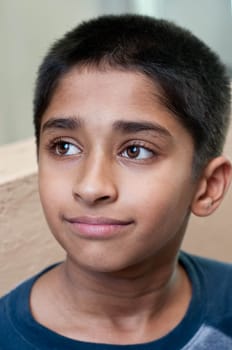 An adorable young Indian boy day dreaming