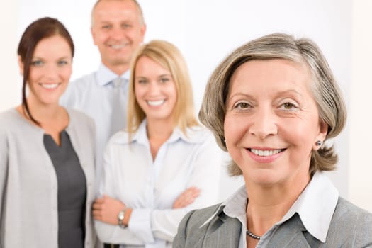 Business team senior businesswoman with attractive happy colleagues in office