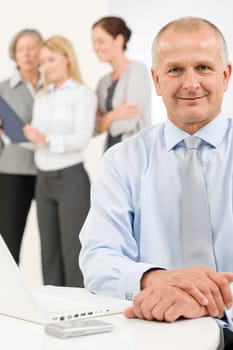 Business team happy mature businessman with attractive colleagues looking file