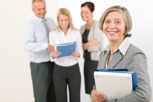 Business team senior businesswoman in front with attractive happy colleagues