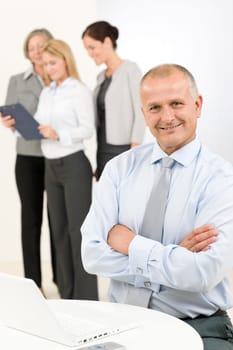 Business team happy mature businessman with attractive colleagues looking file