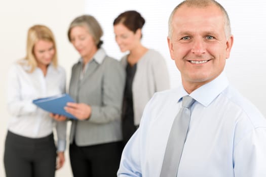 Business team senior businessman in front with attractive happy colleagues