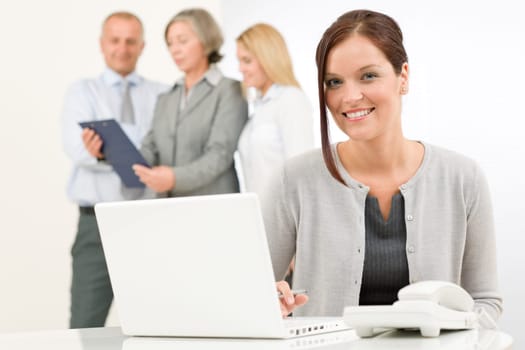 Business team attractive woman with happy colleagues discussing in back