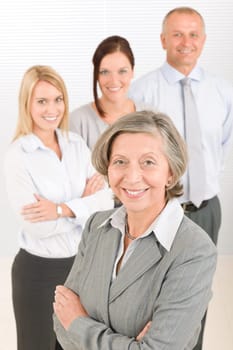 Business team senior businesswoman with attractive happy colleagues in office