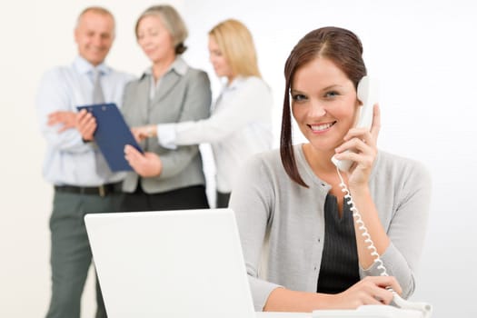 Business team pretty businesswoman calling phone happy colleagues looking folder