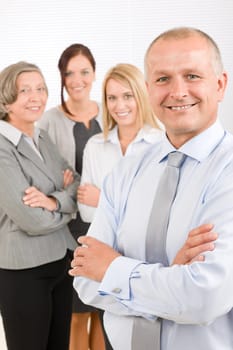 Business team senior businessman with attractive happy colleagues in office