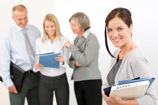Business team attractive woman with happy colleagues discussing in back