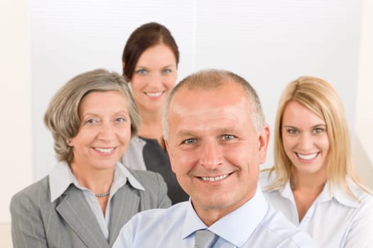 Business team senior businessman with attractive happy colleagues in office