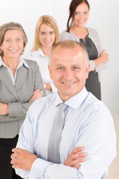 Business team senior businessman with attractive happy colleagues in office