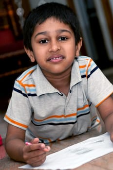 an handsome indian kid doing homework