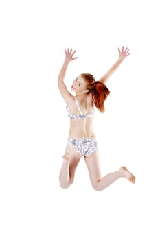 Back view of a smiling young girl jumping and having her hands up, isolated on white background.