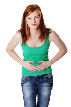Pretty caucasian standing teen girl having a stomachache. Isolated on white.