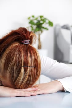 Caucasian woman laying on the desk in the office.