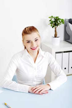 Pretty caucasian woman sitting behind the desk in her office.