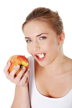 Young beautiful woman eating red apple looking towards camera