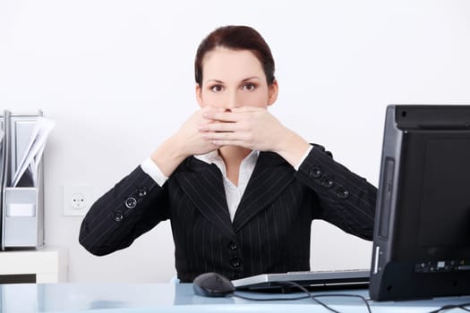 Pretty caucasian businesswoman in the speak no evil pose.