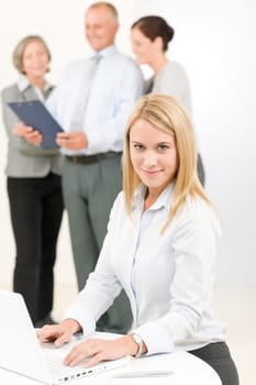 Business team attractive woman with happy colleagues discussing in back