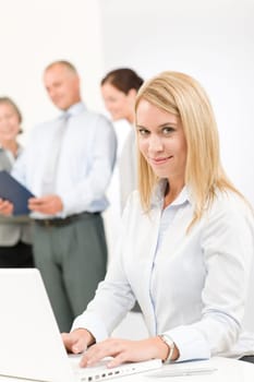 Business team attractive woman with happy colleagues discussing in back