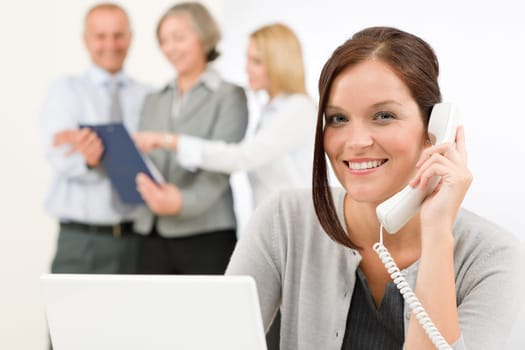 Business team pretty businesswoman calling phone happy colleagues looking folder