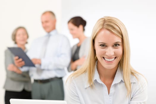 Business team attractive woman with happy colleagues discussing in back
