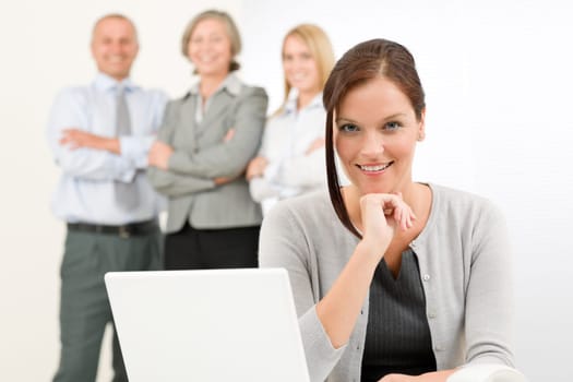 Business team attractive woman with happy colleagues posing in back