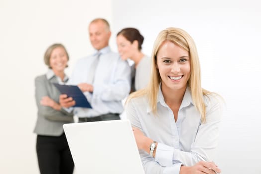Business team attractive woman with happy colleagues discussing in back