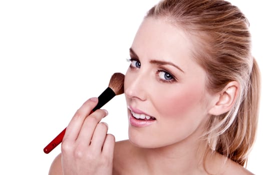 A head shot of a beautiful blond woman applying makeup.