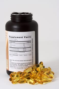Fish oil capsules and bottle on a white background