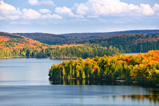 Fall forest of colorful autumn trees on islands in calm lake