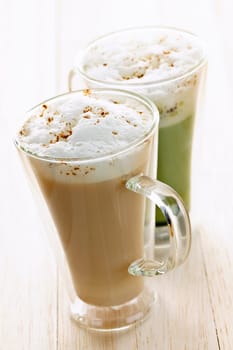 Two specialty tea latte beverages of chai and matcha teas