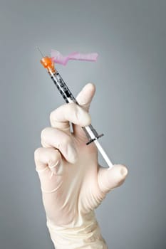 Medical safety syringe held by hand in surgical latex glove
